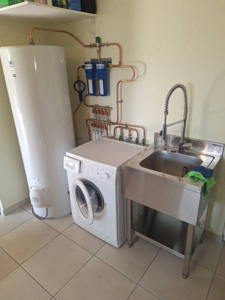 Plombier à Bernay dans l'Eure : installation de chauffe-eau, lave linge et évier inox dans une buanderie